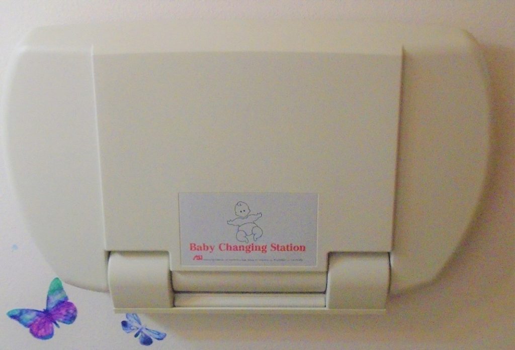 A baby changing station with a blue butterfly on it.